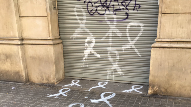 La sede del PSC de Barcelona amanece con lazos blancos pintados en el suelo y en su persiana